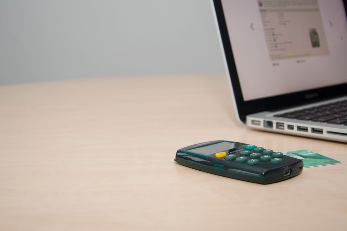 Calculator, laptop and card used to review operating costs.