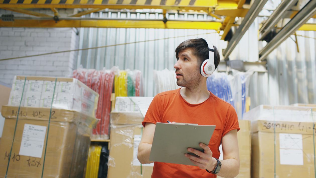 Warehouse operator checking inventory details on a clipboard
