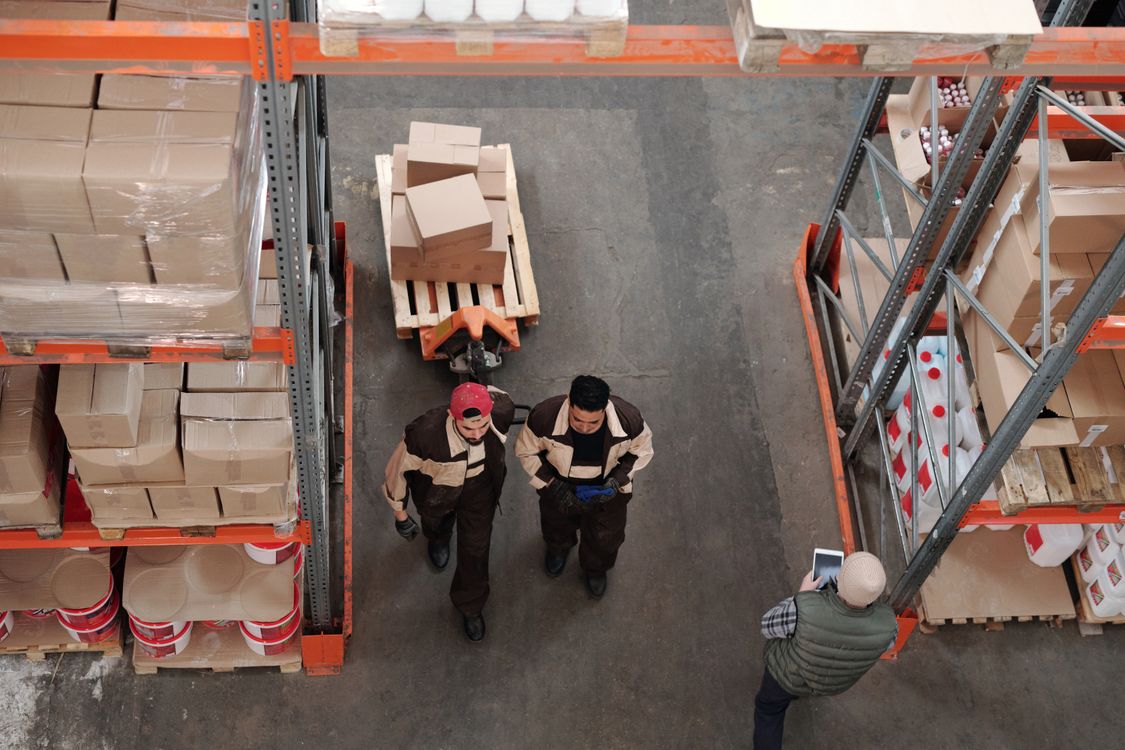 Warehouse workers preparing shipments with boxes and pallets