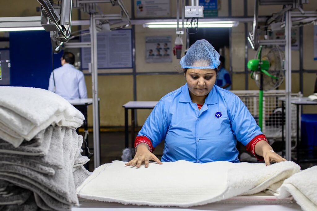 Factory worker inspecting material quality on a production floor